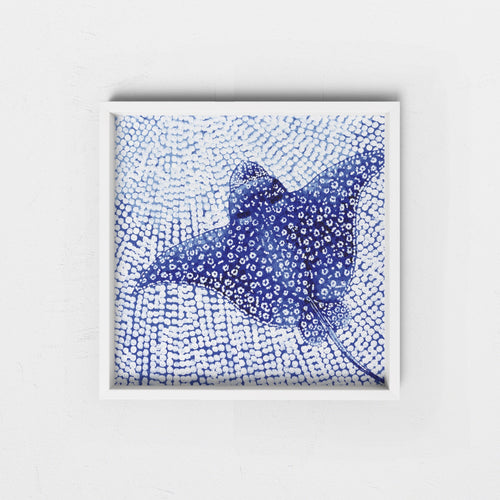 Framed artwork of a blue abstract white spotted eagle ray in a white frame